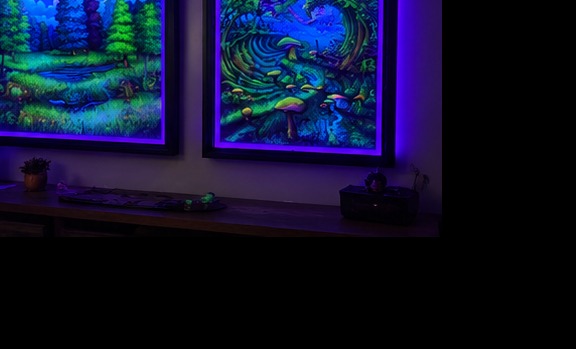 Two illuminated UV art frames in a dark room